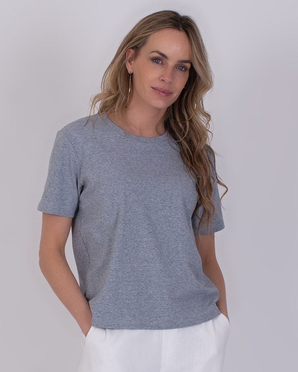 Denver grey 4 Vrouw draagt een Denver grey T-shirt met korte mouwen en witte broek tegen een neutrale achtergrond.