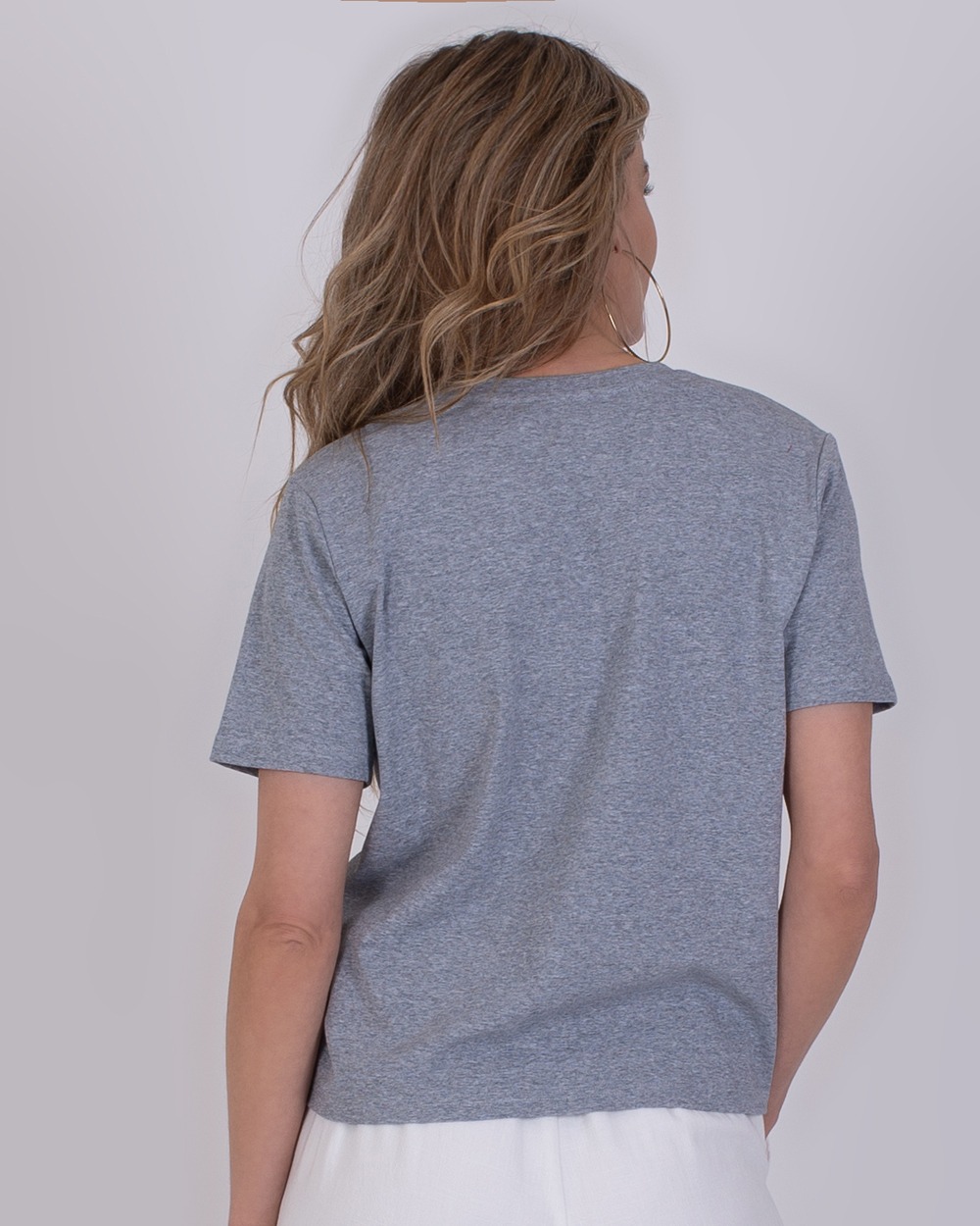 Denver grey 5 Vrouw van achteren gezien die een grijs Denver Grey T-shirt en een witte broek draagt.