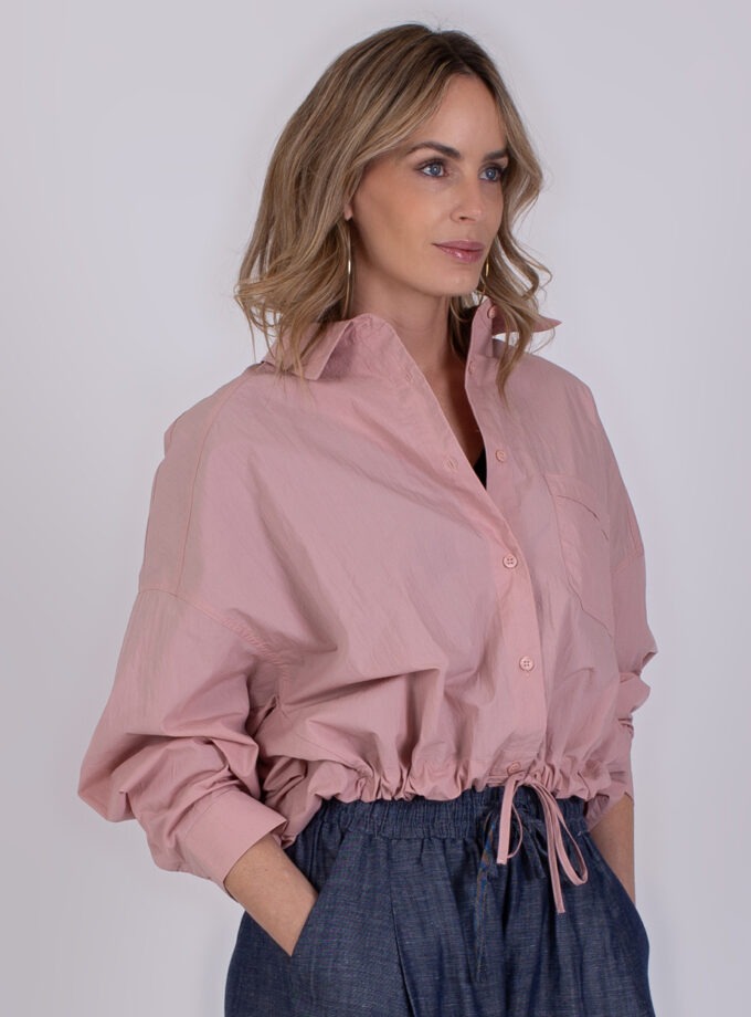 Vrouw draagt een Juba old pink blouse met opstaande kraag en trekkoord in de taille.