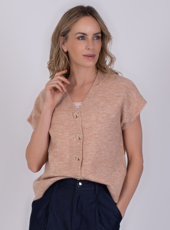 Vrouw draagt een gebreide Lamia old pink top met korte mouwen en knopen aan de voorkant.