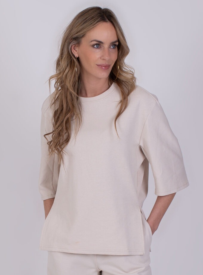 Vrouw draagt een off-white oversized T-shirt met halflange mouwen uit de Malaga-collectie.