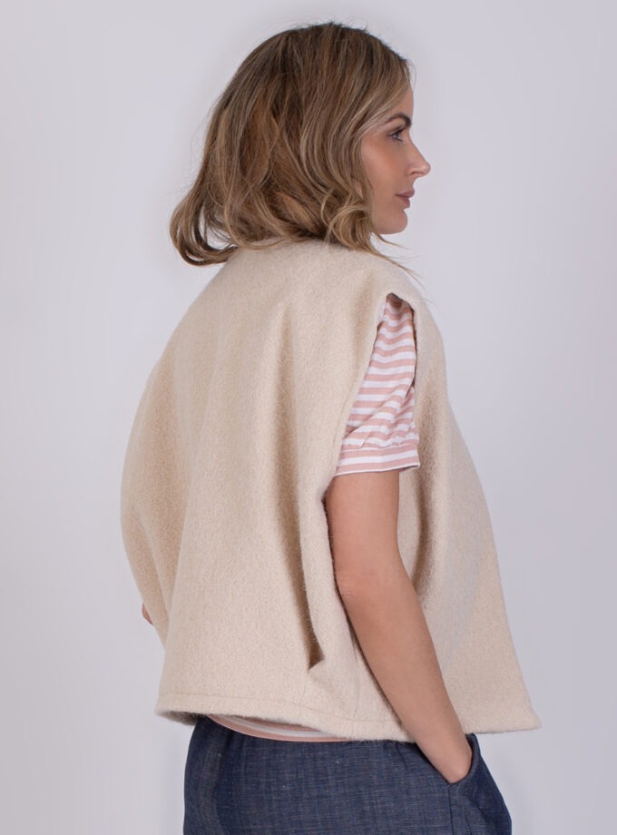 Vrouw draagt een beige Matsumoto teddy bodywarmer over een roze-wit gestreept T-shirt.