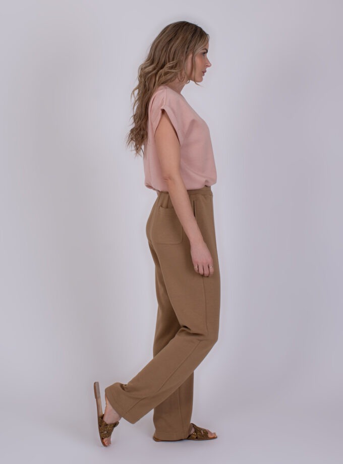 Vrouw in zijaanzicht draagt een roze top en taupekleurige broek genaamd Mesuru taupe 3.