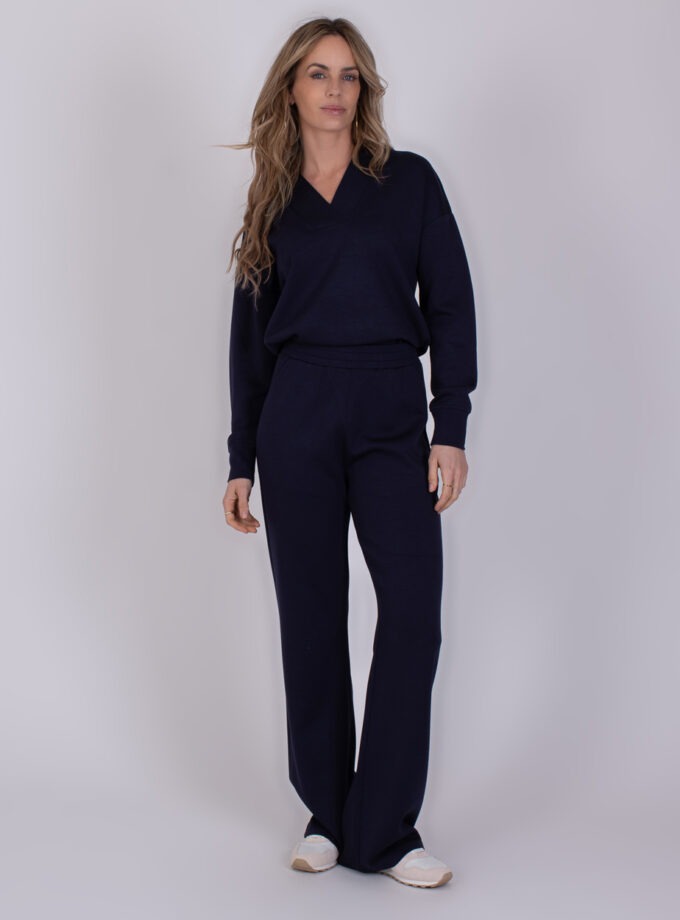Vrouw draagt een donkerblauw Rimini Navy loungewear-set met lange mouwen en wijde broekspijpen.
