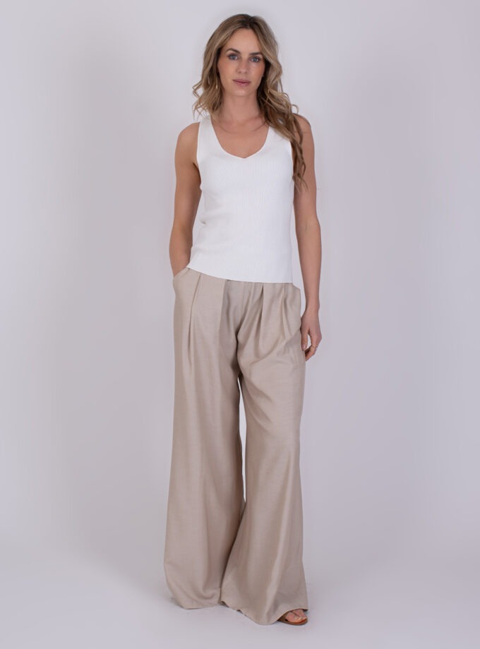 Vrouw draagt een off-white ribtop en beige wijde pantalon uit de Serres-collectie.