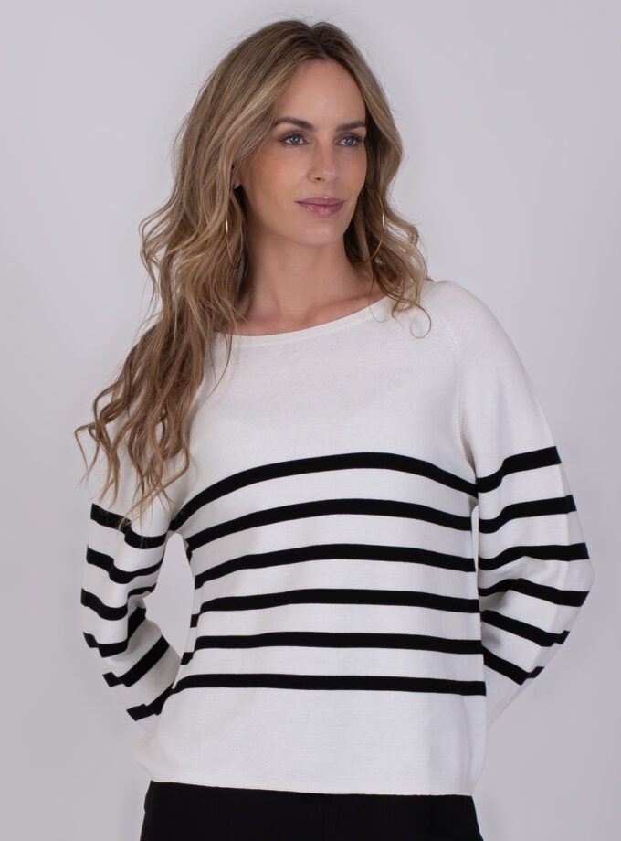 Vrouw draagt de Trikala 3 trui met zwarte horizontale strepen op een witte achtergrond.