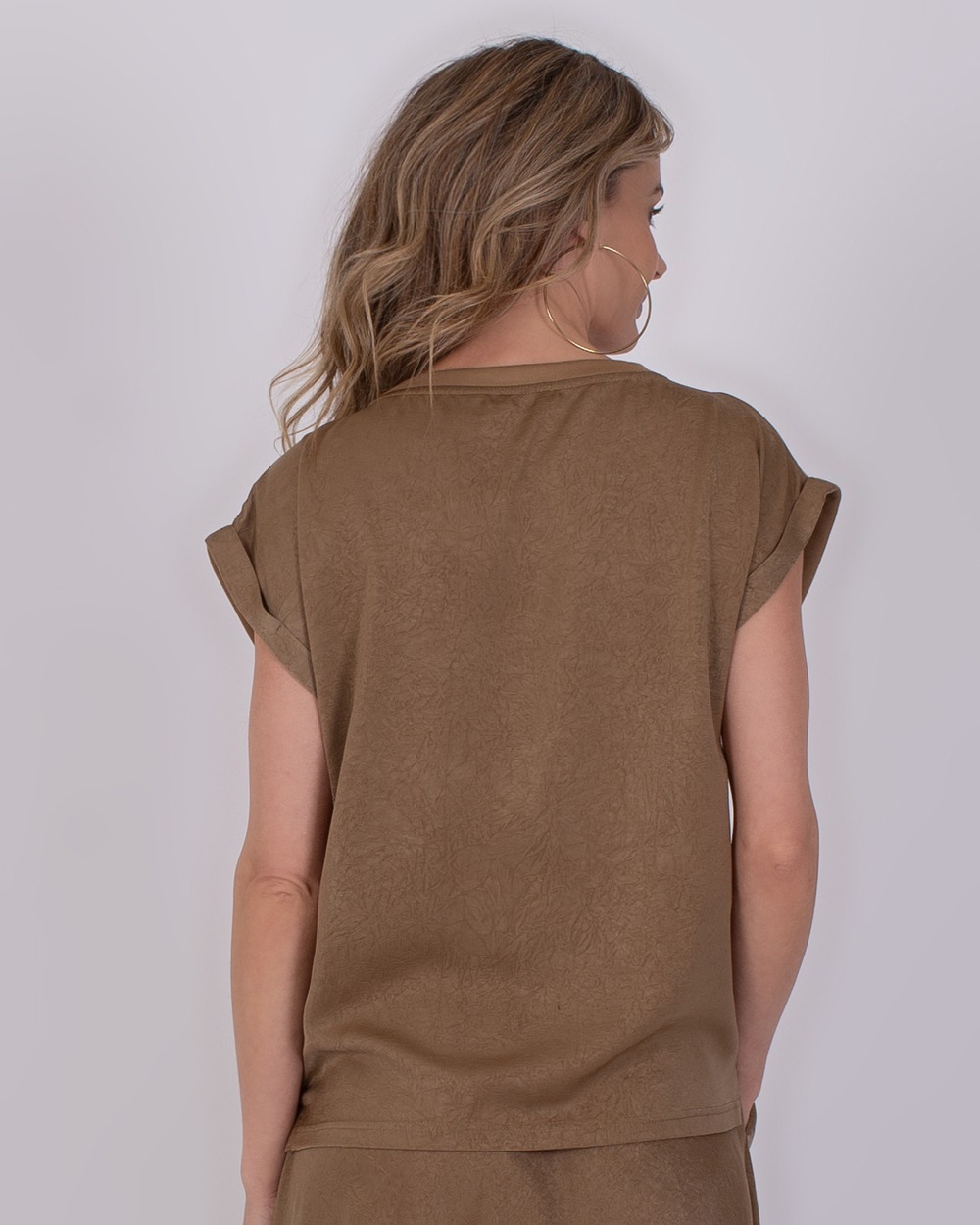 Troje taupe 6 Vrouw van achteren in een taupekleurige top en short uit de Troje taupe 6 collectie.