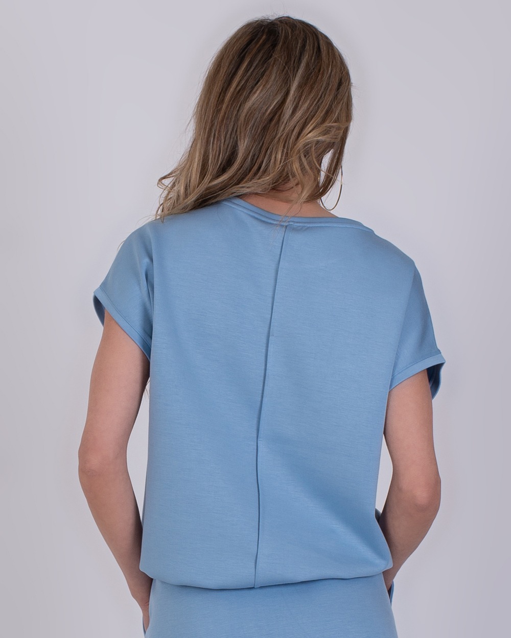 Umea soft blue 5 Achteraanzicht van een vrouw die een lichtblauwe Umea soft blue top draagt.