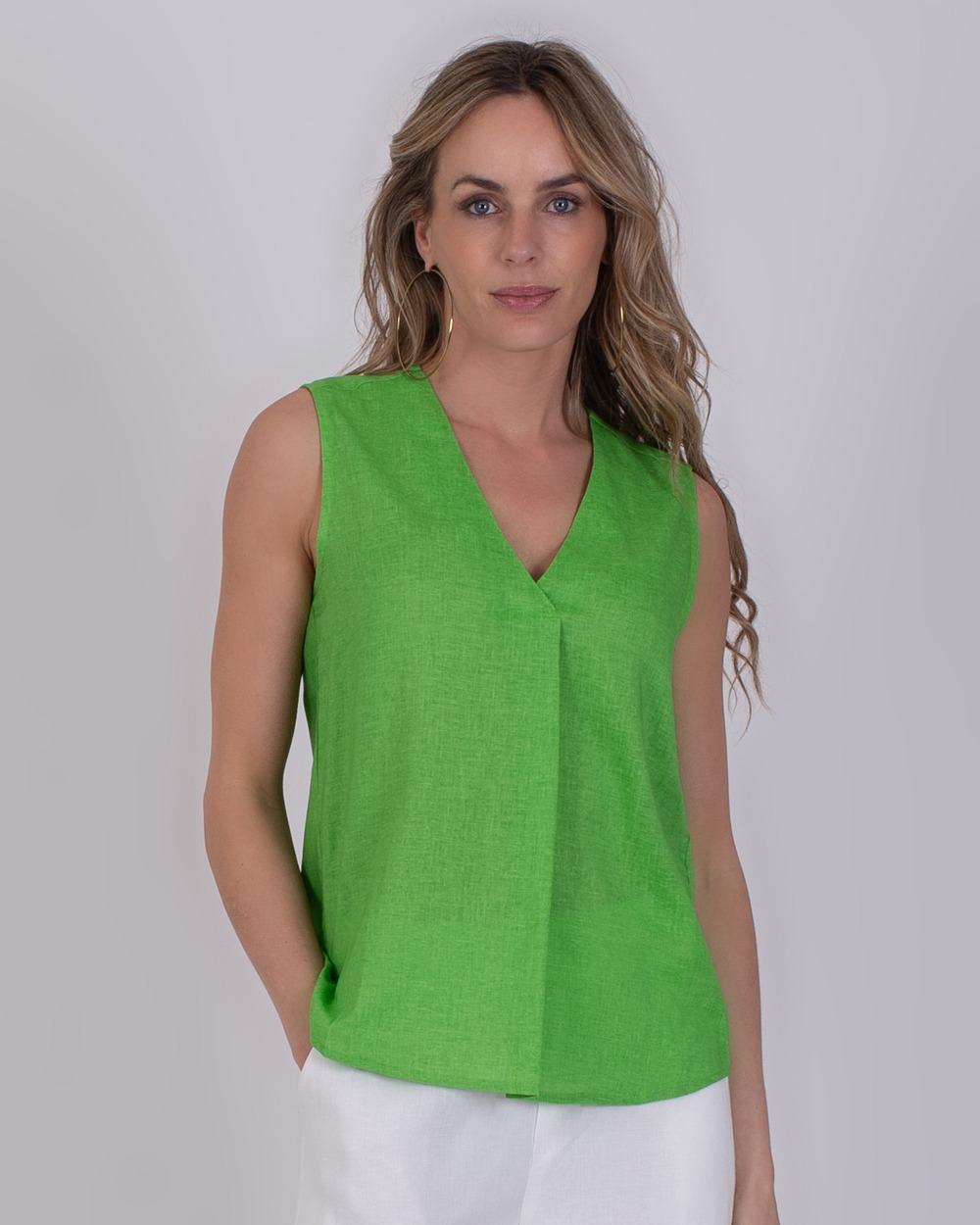 Vrouw draagt een mouwloze, felgroene Valdris-top met V-hals.