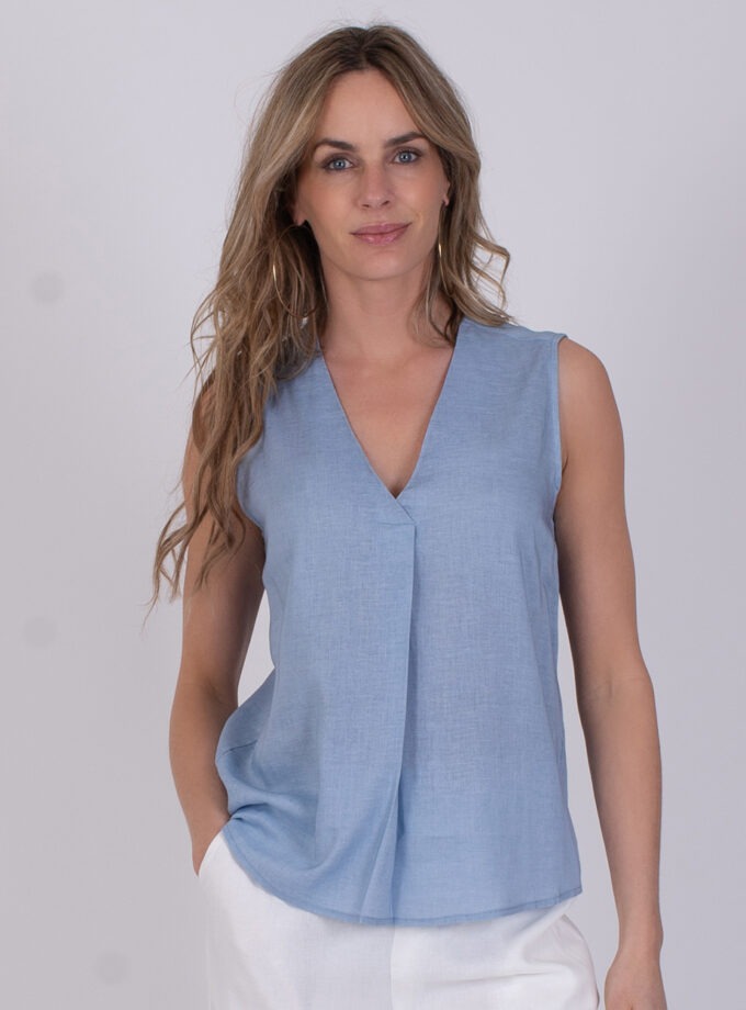 Vrouw draagt een mouwloze, lichtblauwe Valdris top met V-hals.