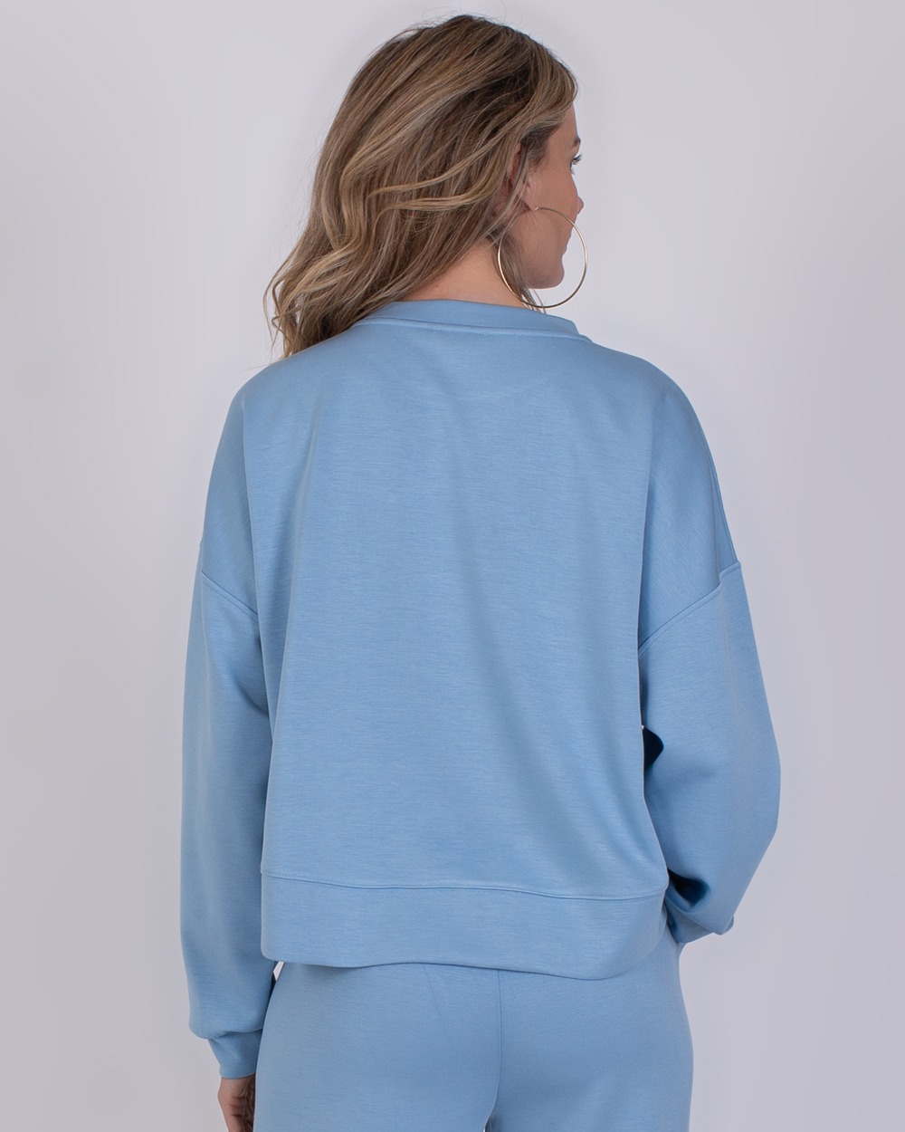 York soft blue 4 Achteraanzicht van een vrouw die een lichtblauwe York soft blue sweatshirt en bijpassende broek draagt.