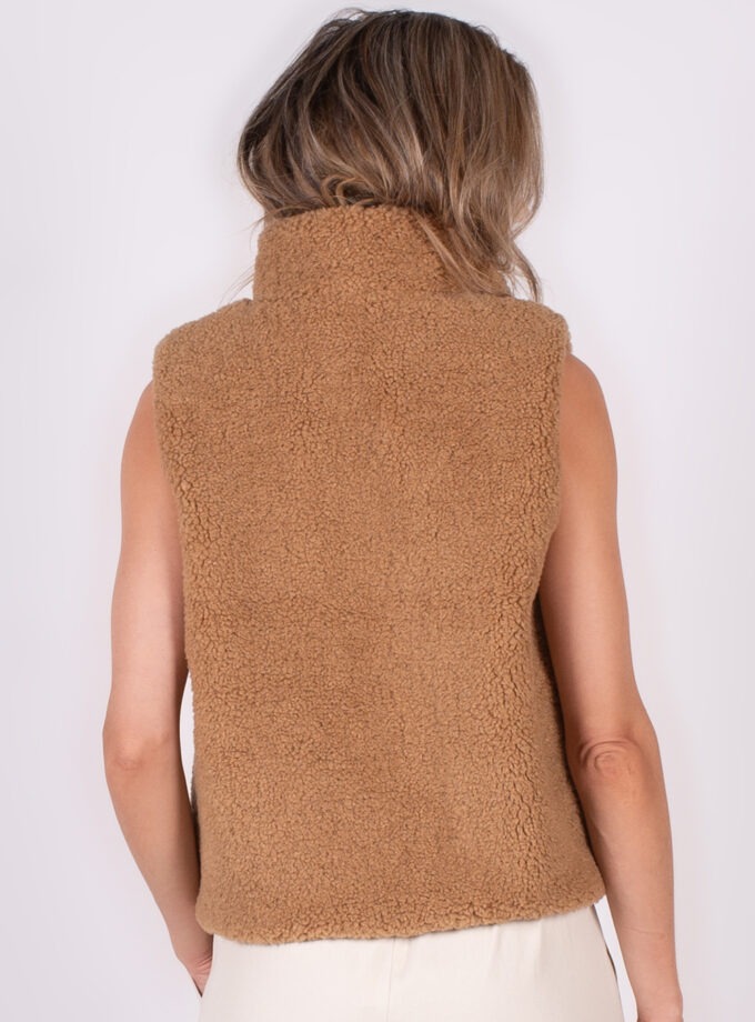 Achteraanzicht van een vrouw die een bruine, pluizige Regina gilet draagt.
