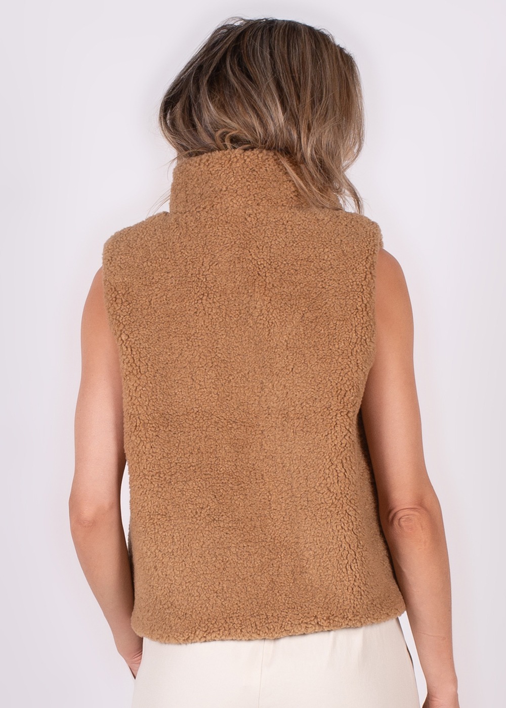 Achteraanzicht van een vrouw die een bruine, pluizige Regina gilet draagt.